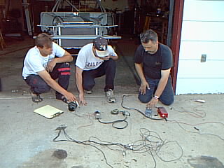 Alex our driver ( in black ) AJ Wlliams ( left ) and Darren Schoonbbaert ( center ) trying to minimize wiring
